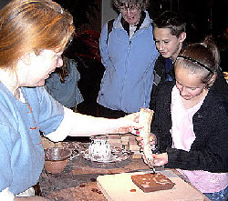 pouring the white clay slip into the stamped tile pattern