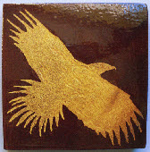 Dark encuastic eagle carved into clay with honey glaze