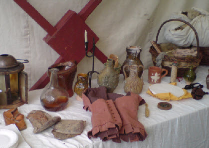 witch bottles, clothing, tudor shoes and dried frogs on a table